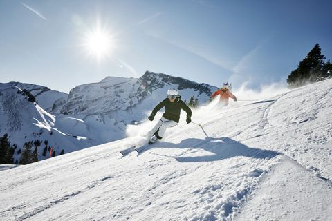 Ein Mann und eine Frau fahren auf der Klewenstockpiste auf der Klewenalp Ski.